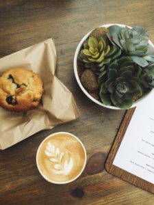 Coffee and a muffin on a table at a cafe