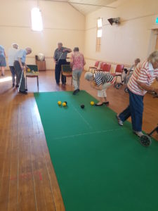 Monday Bowls club members bowling on the green indoors